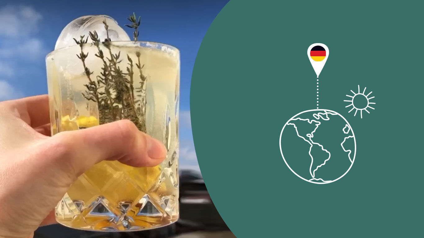 Hand houdt glas met zomerlimonade omhoog naar de hemel. 